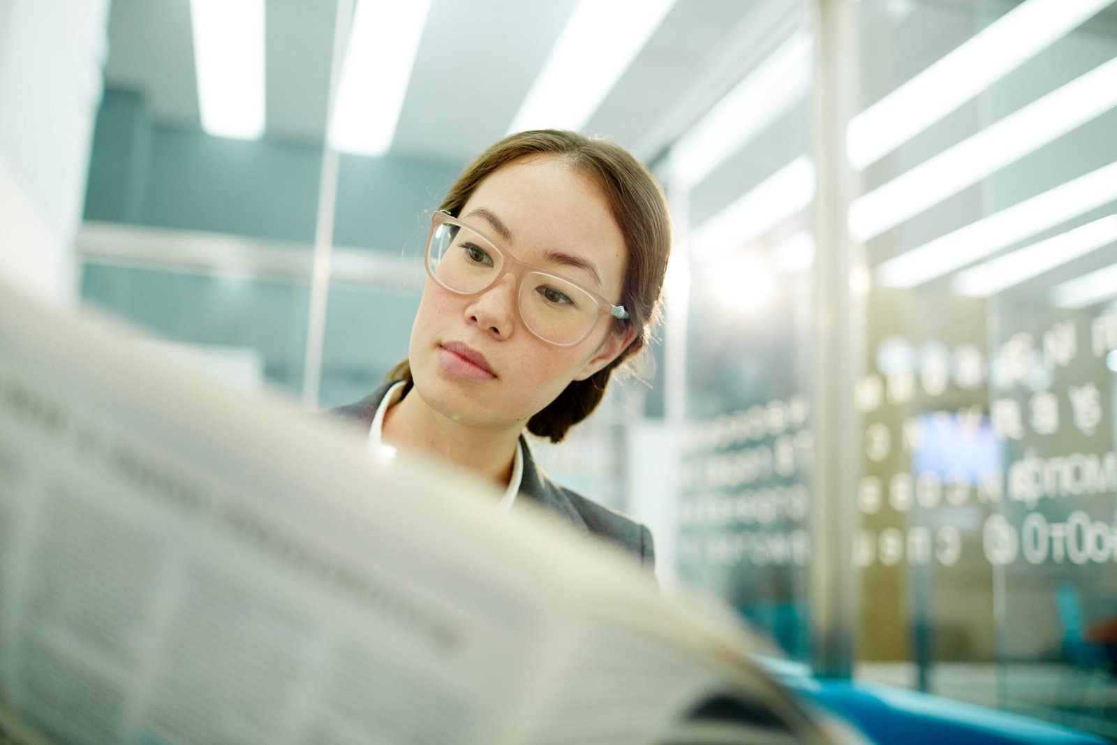 Mulher cientista asiática lendo jornal dentro de um laboratório - Como ler e criar conteúdos de divulgação de ciências