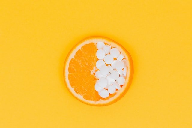 laranja aberta coberta por comprimidos - erros na interpretação de dados científicos - vitamina C