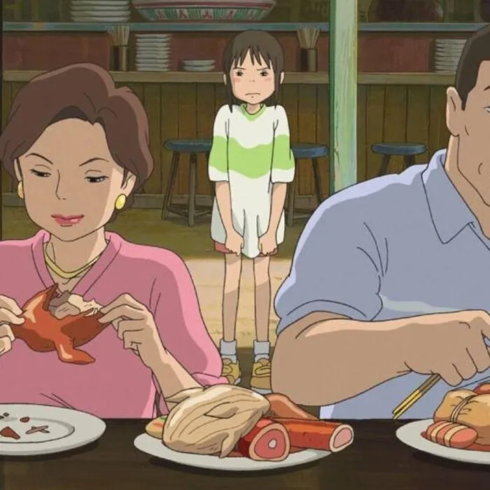 Pais de Chihiro comendo antes de se transformarem em porcos em A Viagem de Chihiro.