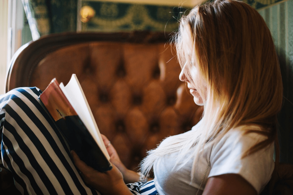 Mulher atraente lendo livro no sofá