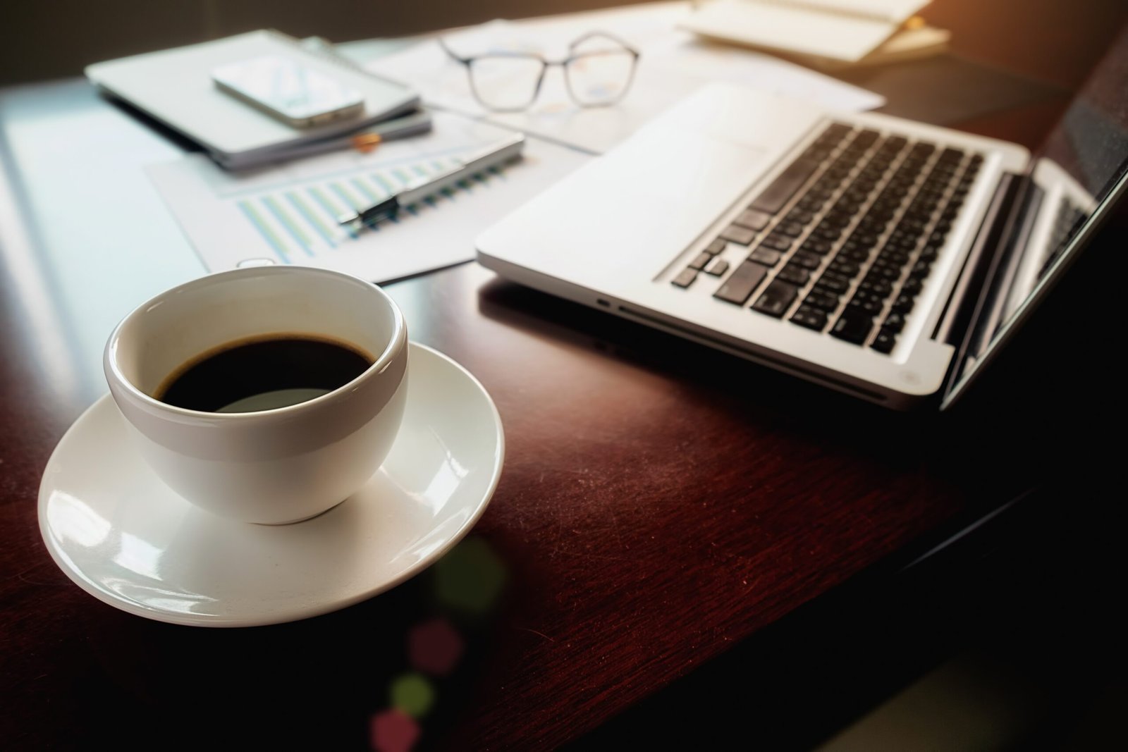 café na mesa com laptop e caderno - café estimula criatividade