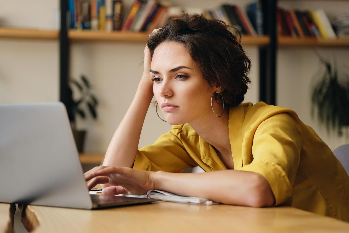 Mulher exausta debruçada sobre a mesa, usando o computador durante o trabalho home ofice