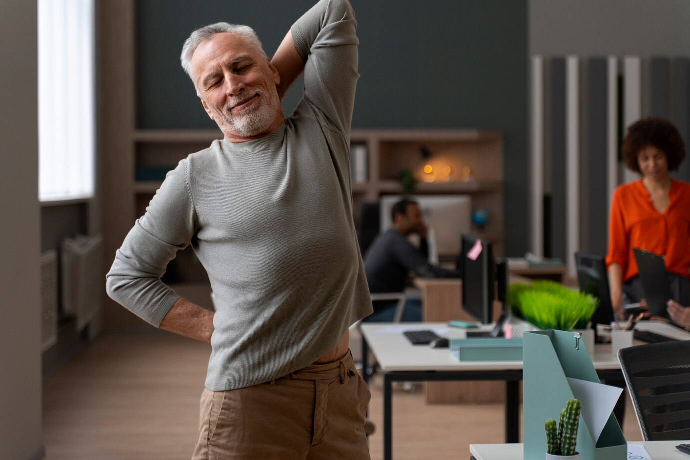 Homem idoso em forma se alongando durante o dia de trabalho como redator.