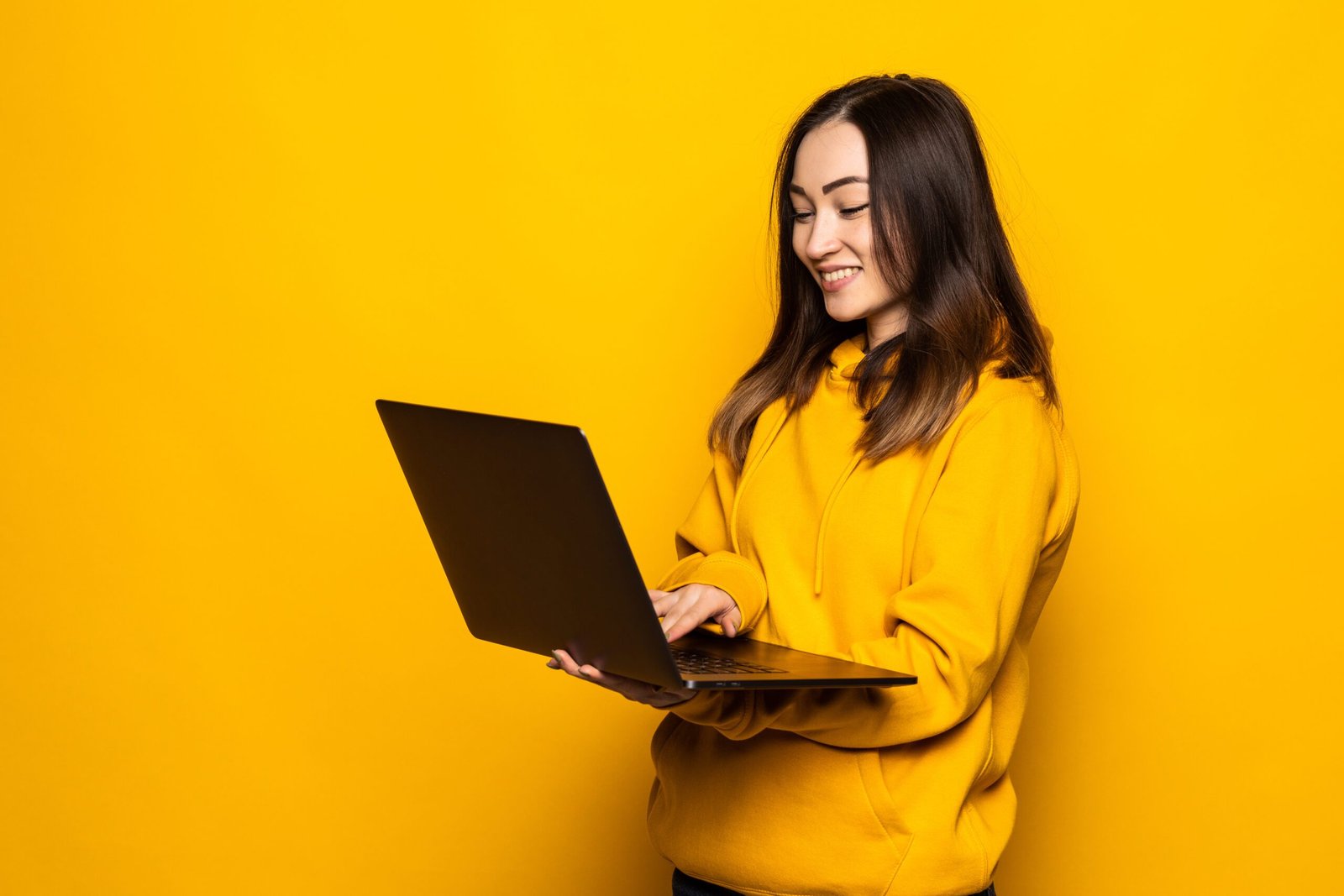 Mulher jovem asiática segurando notebook em fundo branco - Notebook bom e barato - Notebook baratinho e bom