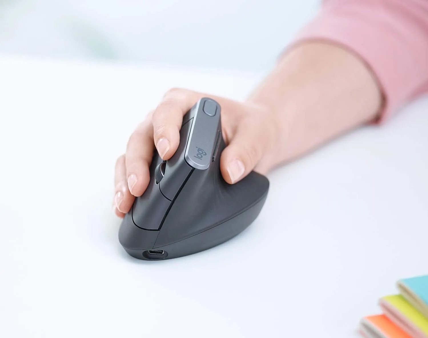Mulher usando mouse ergonômico da Logitech, mulher com unhas feitas usando mouse ergonômico, mouse ergonômico vertical, melhor mouse ergonômico
