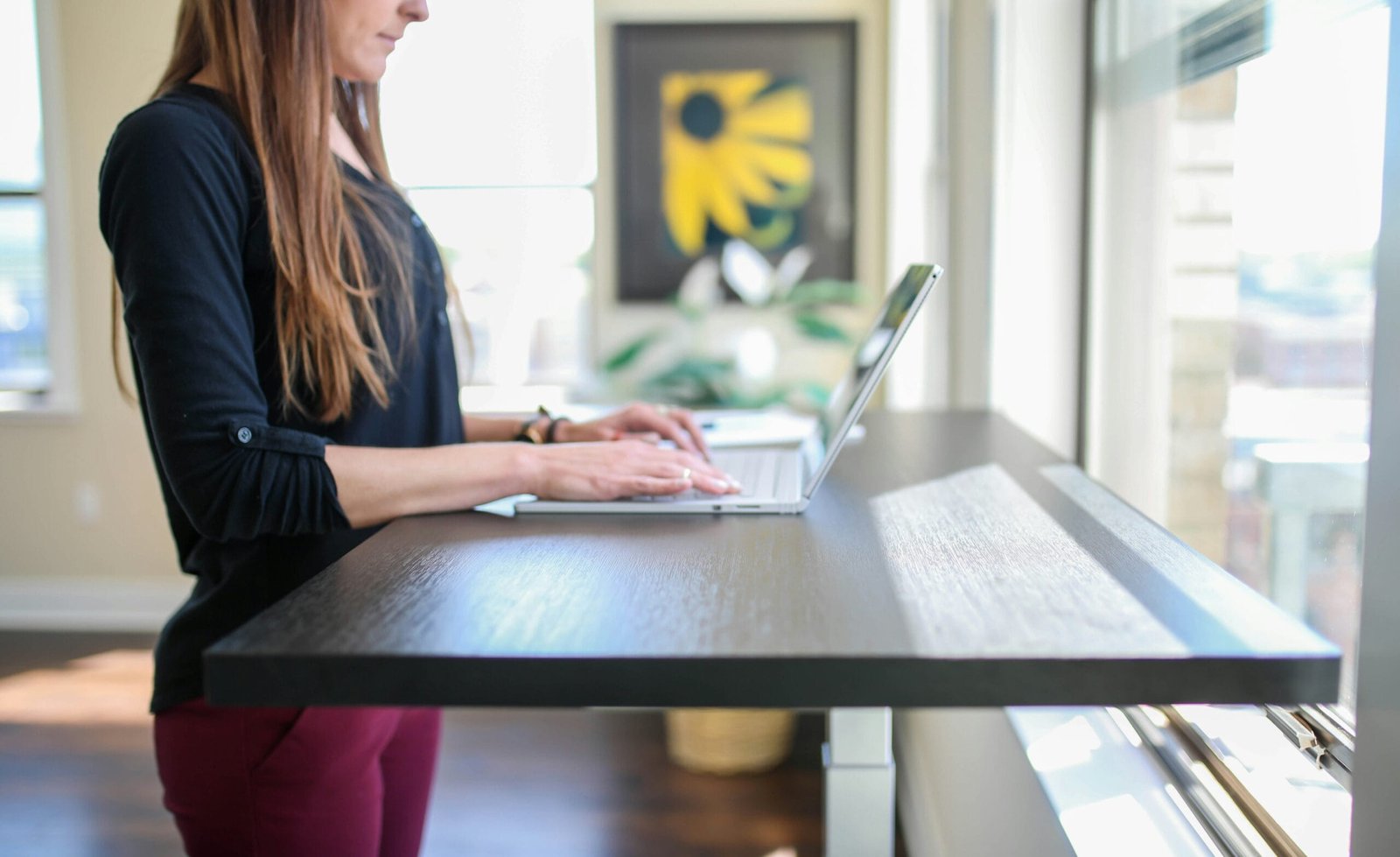 Mulher trabalhando de pé usando mesa com regulagem de altura elétrica, bela mulher em escritório, ergonomia