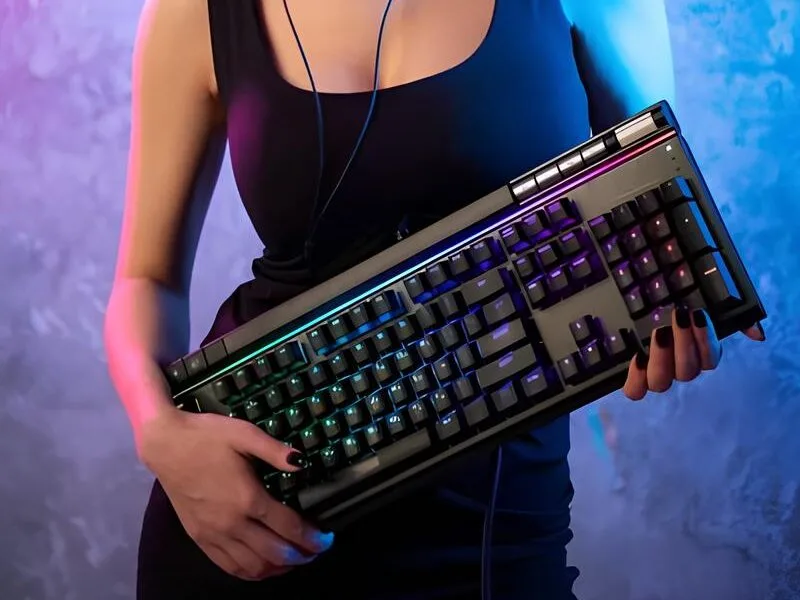 mulher gamer sexy segurando teclado mecânico