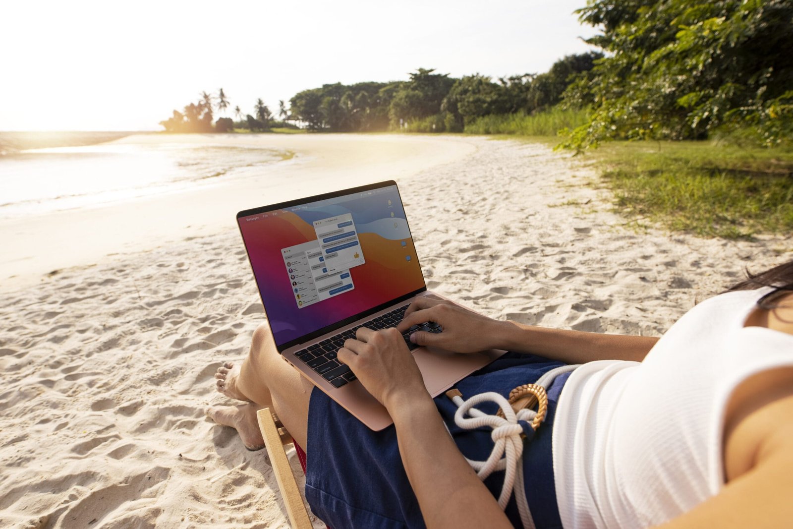 Mulher trabalhando no notebook no meio da praia - Vale a pena ser nômade digital