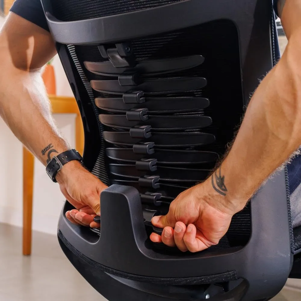 Homem forte jovem ajustando o apoio lombar da cadeira ergonômica Vertta Pro