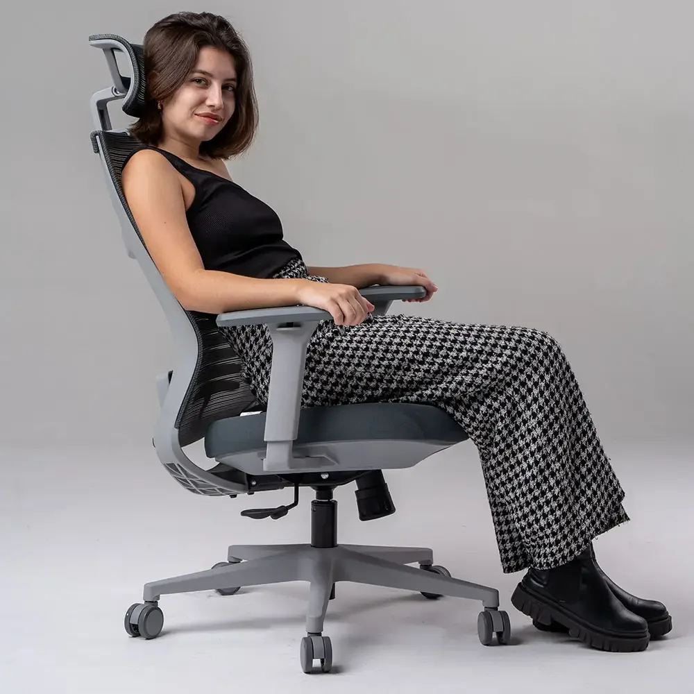 Garota jovem bonita com calça xadrez sentada na cadeira Elements Vertta