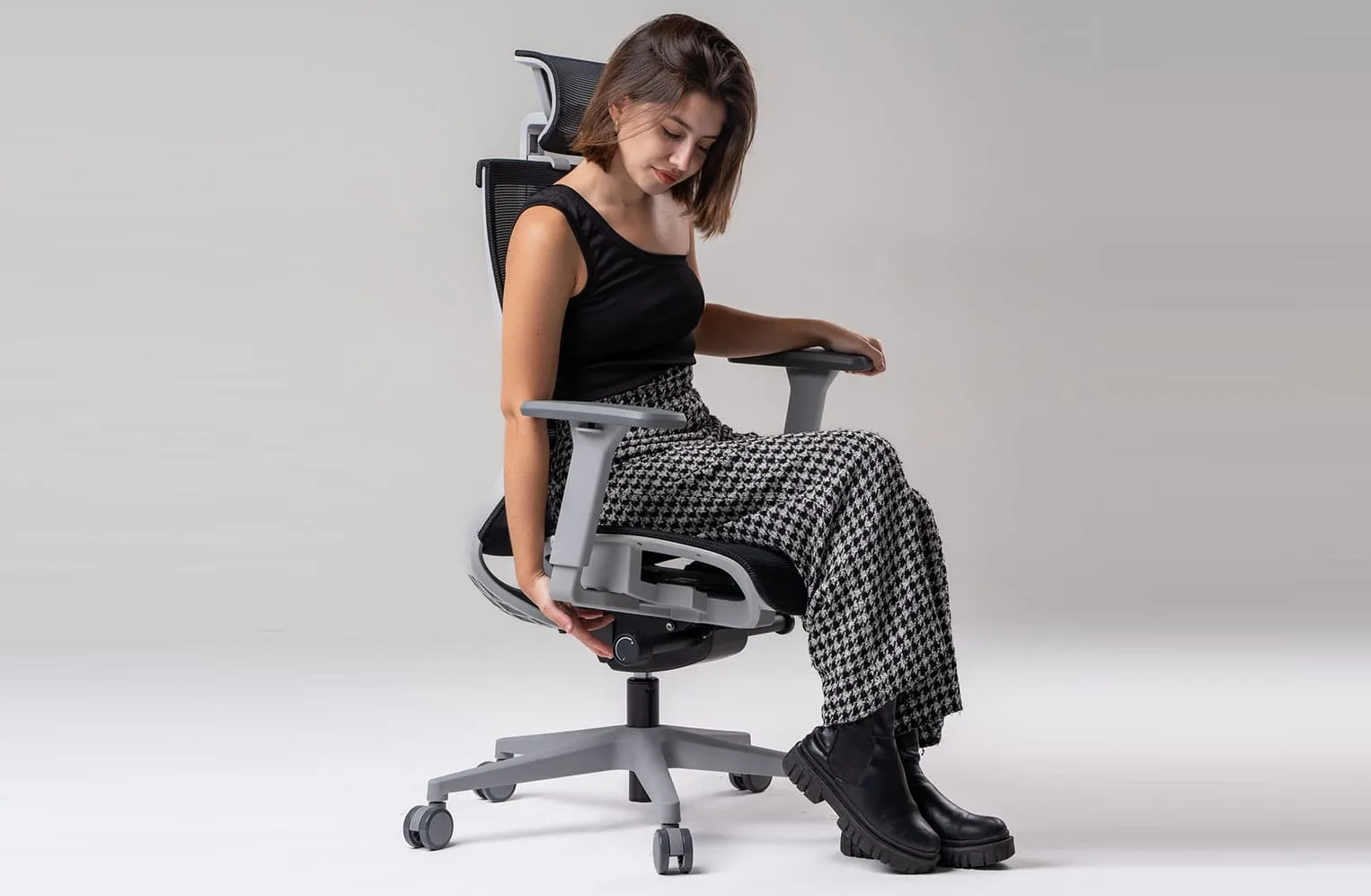 Mulher jovem ajustando cadeira ergonômica Vertta Pro