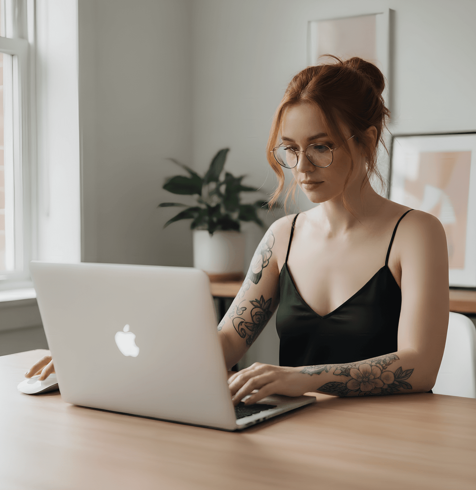 Garota ruiva bonita com tatuagens nos braços usando um MacBook no home office, melhor macbook, ruiva, tatuagem de flor, comprar macbook vale a pena, melhor macbook