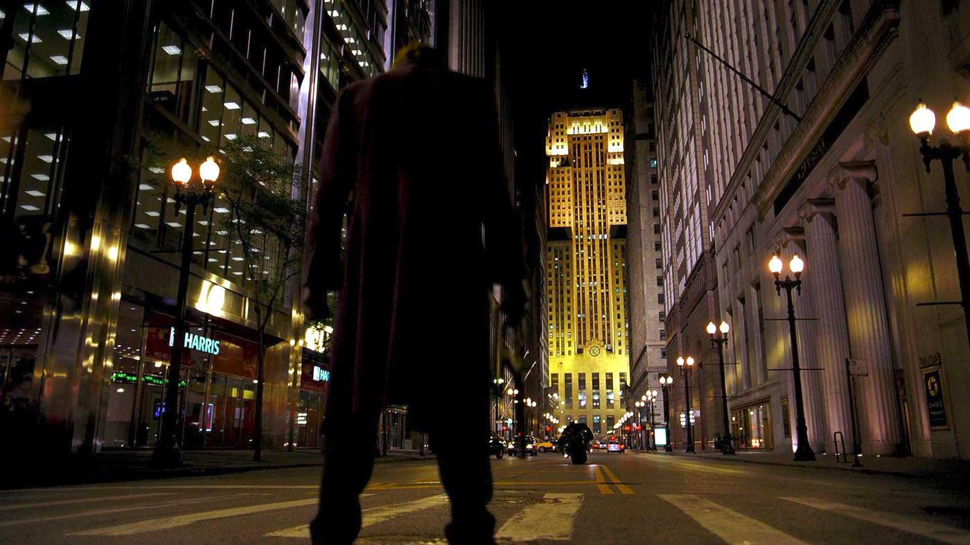 Confronto entre Batman e Coringa na avenida, em cena de "Batman: O Cavaleiro das Trevas"